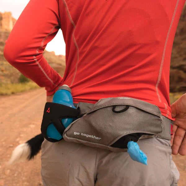 KURGO® Excursion Running Belt worn by woman, rear view featuring water bottle holder and easily accessible poop bag