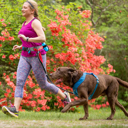 KURGO® Excursion Running Belt worn by woman attached to her dog by a KURGO Springback Leash whilst running together, side view